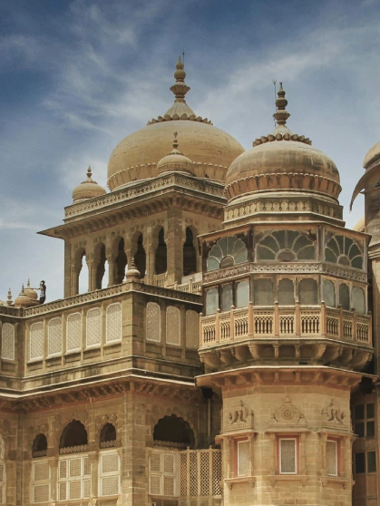 A bird perched on an iron rod with trees in background
