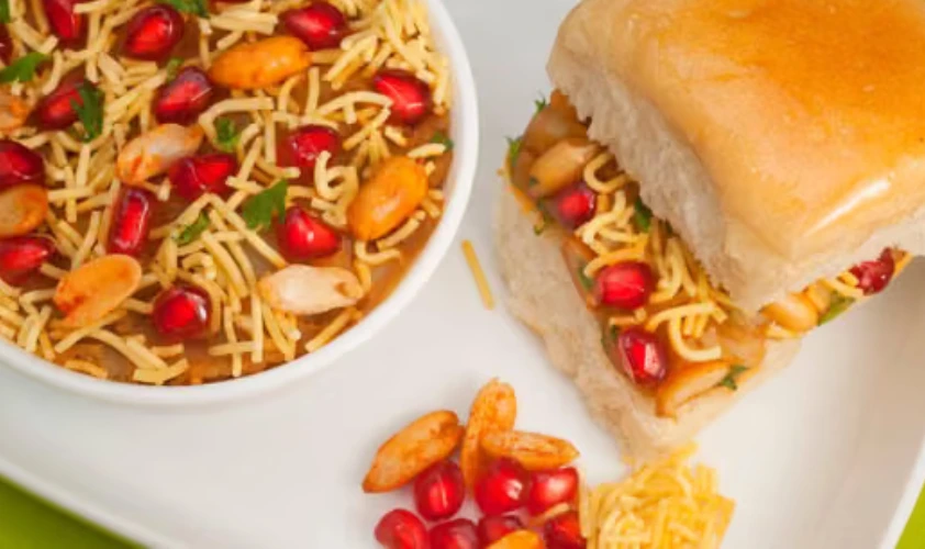 Plate of dabeli with pomegranate and sev filling