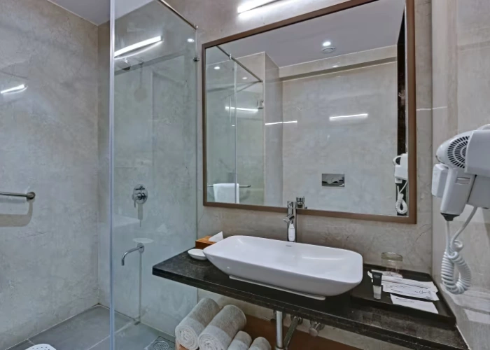Elegant Interiors in Deluxe Twin Room at Orchid Hotel Jamnagar Well-Lit Twin Room Interior with Modern Decor