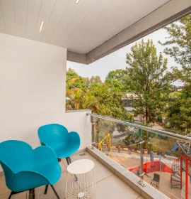 Dew Drop Mist Balcony Room private balcony with blue chairs and lush nature view at hotel in Panchgani