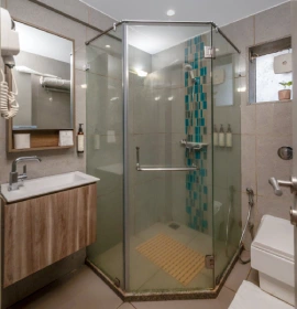 Dew Drop Mist Balcony Room bathroom with glass shower enclosure and teal mosaic tiles at hotel in Panchgani