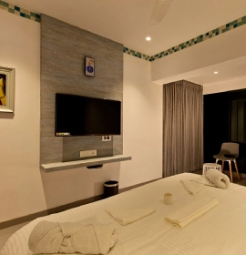 Stay inOrchid hotel with Modern amenities in Dew Drop Mist Balcony Room in Panchgani, including Wi-Fi and flat-screen TV