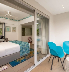 Dew Drop Mist Balcony Room view from balcony with queen bed and blue chairs at hotel in Panchgani