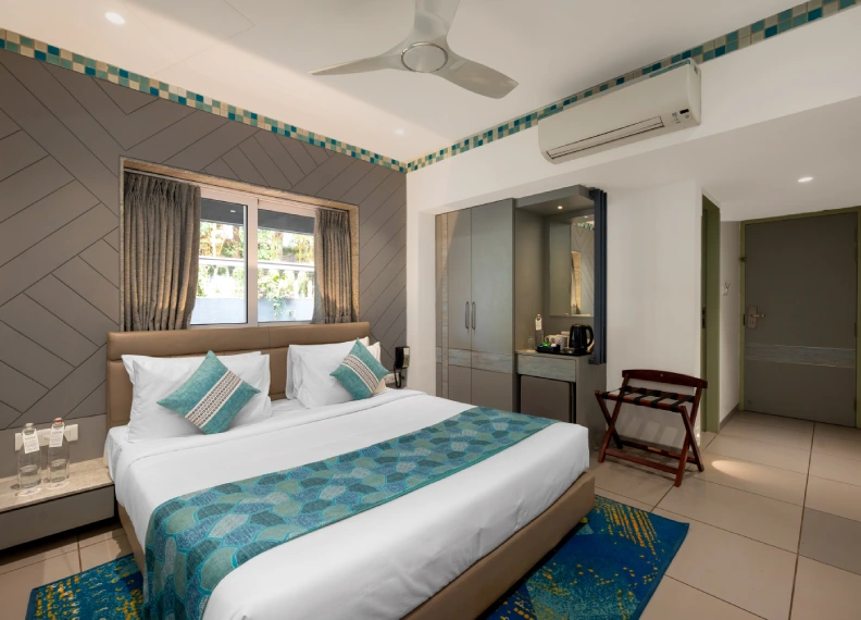 Dew Drop Room with queen bed, AC, ceiling fan and teal decor at Orchid Hotel Panchgani