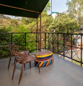 Forest Tent Private Balcony with Valley Green Views - Panchgani Forest Tent private balcony with colorful ottoman chair and lush green valley views at eco resort Panchgani