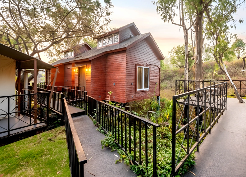 Spacious Tree House Suite entrance hallway with view into living room and wooden flooring at Orchid Hotel Panchgani