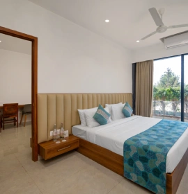 Wooden Tree House king bed room with AC, ceiling fan, wooden headboard and green nature view window in Panchgani