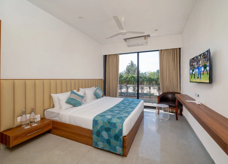 Wooden Tree House spacious room with king bed, wall-mounted smart TV, AC, ceiling fan and balcony nature view in Panchgani