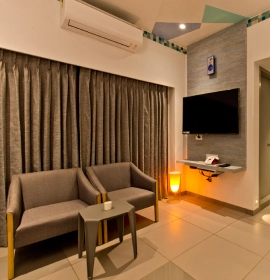 Living space with a sofa in the Tree House Suite at Orchid Hotel in Panchgani near Mahabaleshwar