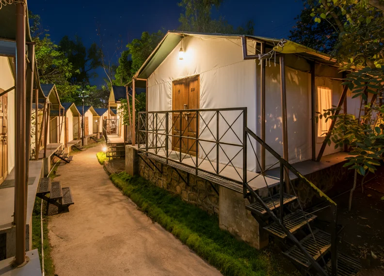 Forest Tent Night View Illuminated Exterior - Eco Resort Panchgani Forest Tent eco resort exterior illuminated at night with pathway lighting and lush greenery in Panchgani